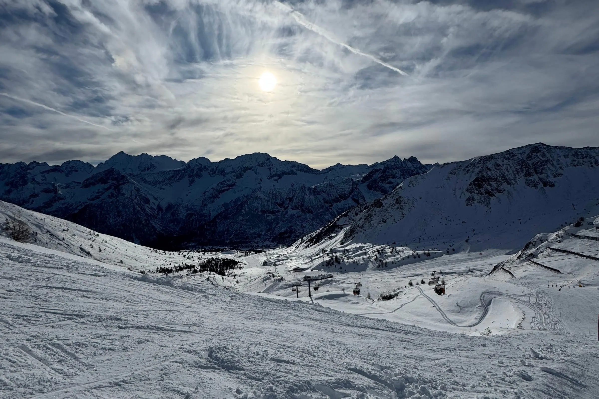 Passo del Tonale zimą: zaśnieżona misa z przygotowanymi trasami, wyciągami i szczytami w tle